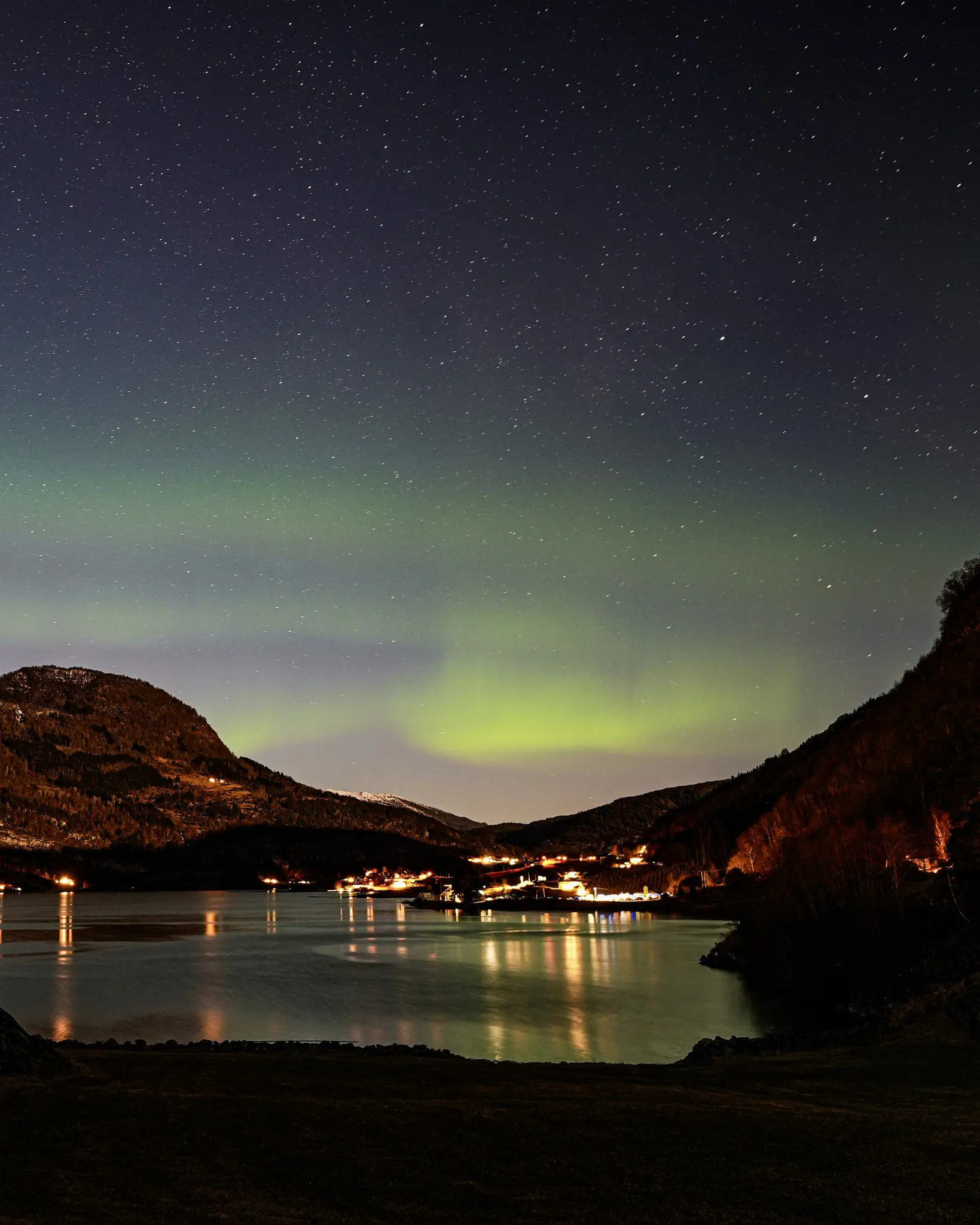 northern lights over a Norwegian fjord village at night