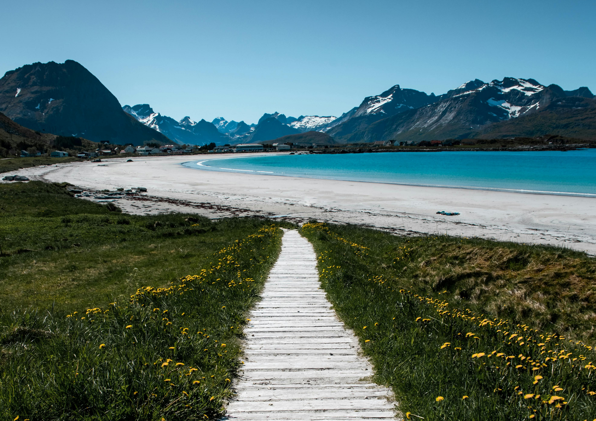 wooden boardwalk leading to a white sand beach in Lofoten